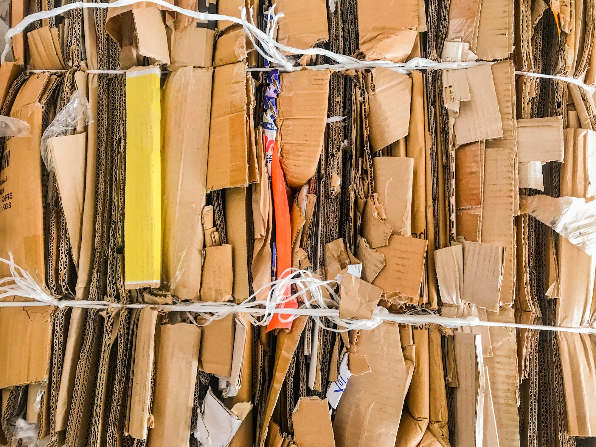 Bundle of colorful wastepaper cardboard to be recycled. Paper cardboard is bundled into bale